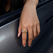 AUREL yellow oval lab-grown gemstone ring with moissanite pav¨¦, worn on a hand resting on a car door.