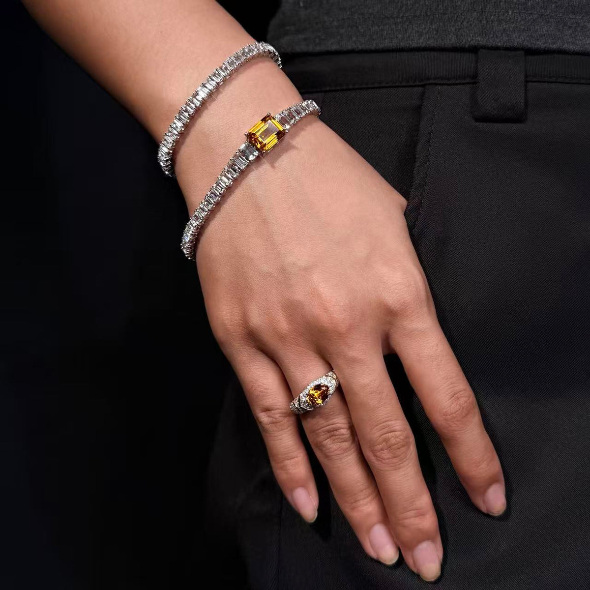 DREXEY yellow gemstone tennis bracelet and east-west oval ring worn with black clothing