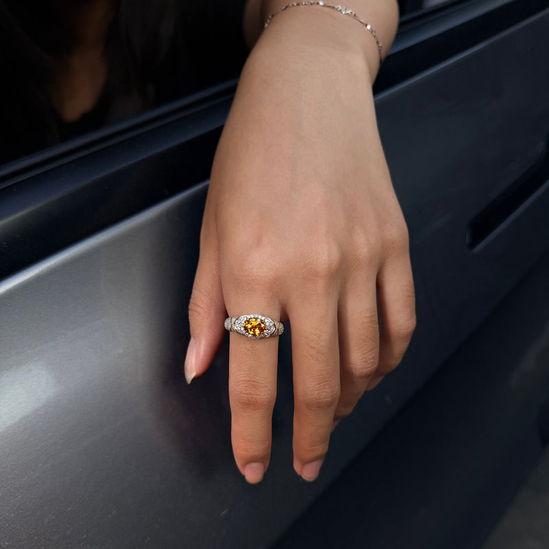 AUREL yellow oval lab-grown gemstone ring with moissanite pav¨¦, worn on a hand resting on a car door.