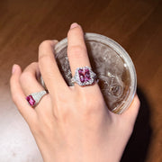 REINE pink gemstone halo ring and pink pav¨¦ ring shown on a hand holding a glass