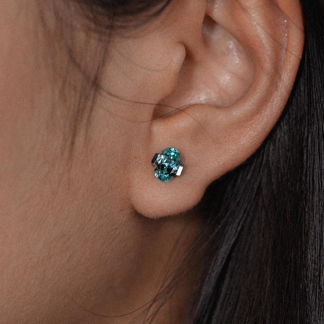Sapphire oval-cut earrings with hand-set setting close-up view highlighting the gemstone cut and setting details