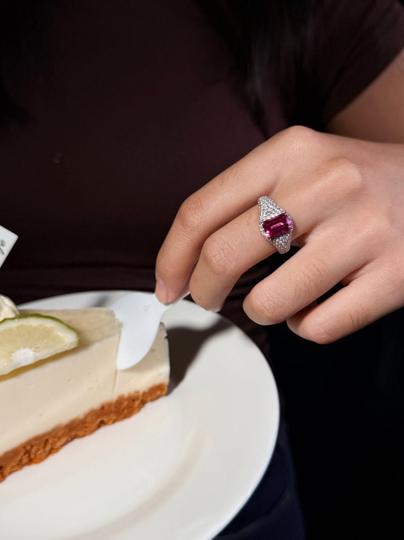 VAREN pink emerald-cut gemstone pav¨¦ ring worn beside a dessert plate