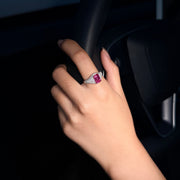 VAREN hot pink emerald-cut lab-grown gemstone ring with moissanite pav¨¦ shoulders, worn on a hand inside a car.