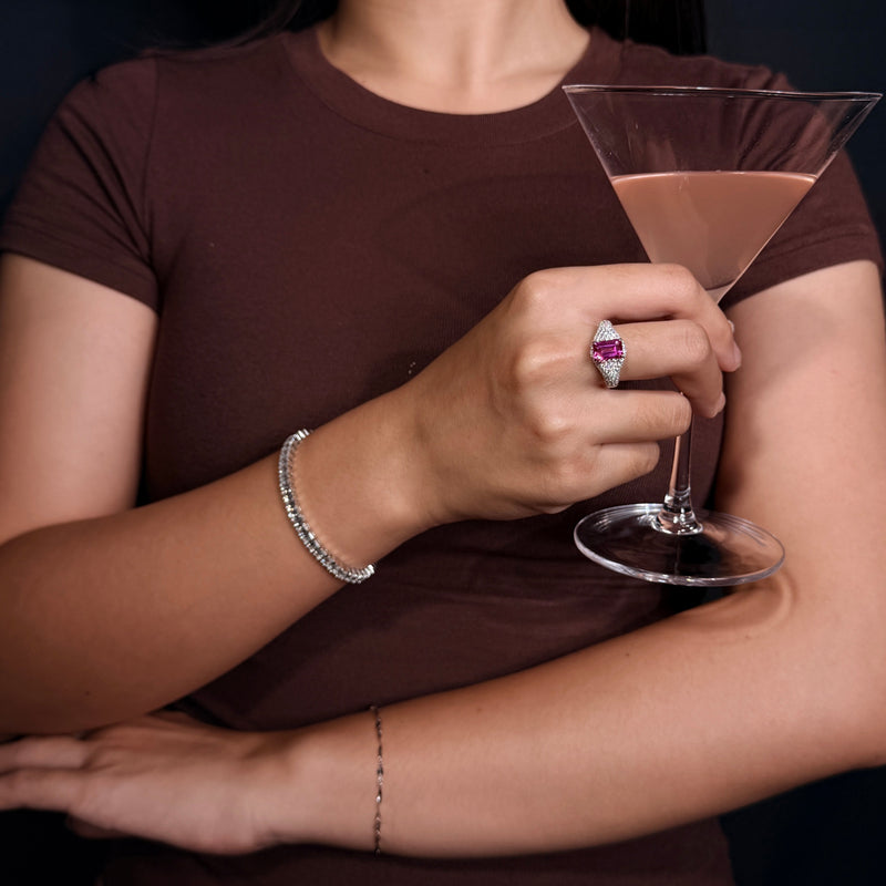 VAREN pink gemstone ring styled with a brown top while holding a cocktail glass